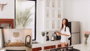 A modern kitchen with a large window, a stove, and a refrigerator.