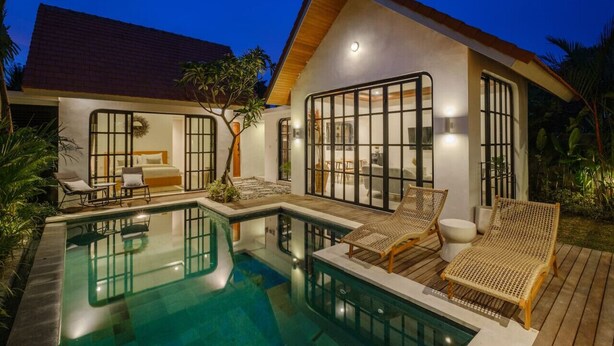 Uma casa moderna com piscina, janelas amplas e mobiliário de exterior.
