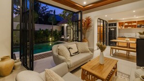 Uma sala de estar moderna com piscina, cozinha aberta e área de jantar.