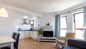En kompakt bolig med spiseplads, tekøkken og siddeområde.