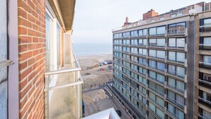 Um edifício alto com várias varandas com vista para a praia.