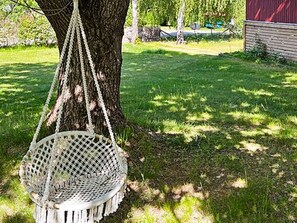A tree with a hanging white swing chair. - 4 Person Holiday Home in Sodertalje (Sodertalje)