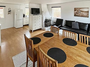 A modern living room with a wooden dining table, black chairs, a black sofa, and a television. - 4 Person Holiday Home in Sodertalje (Sodertalje)