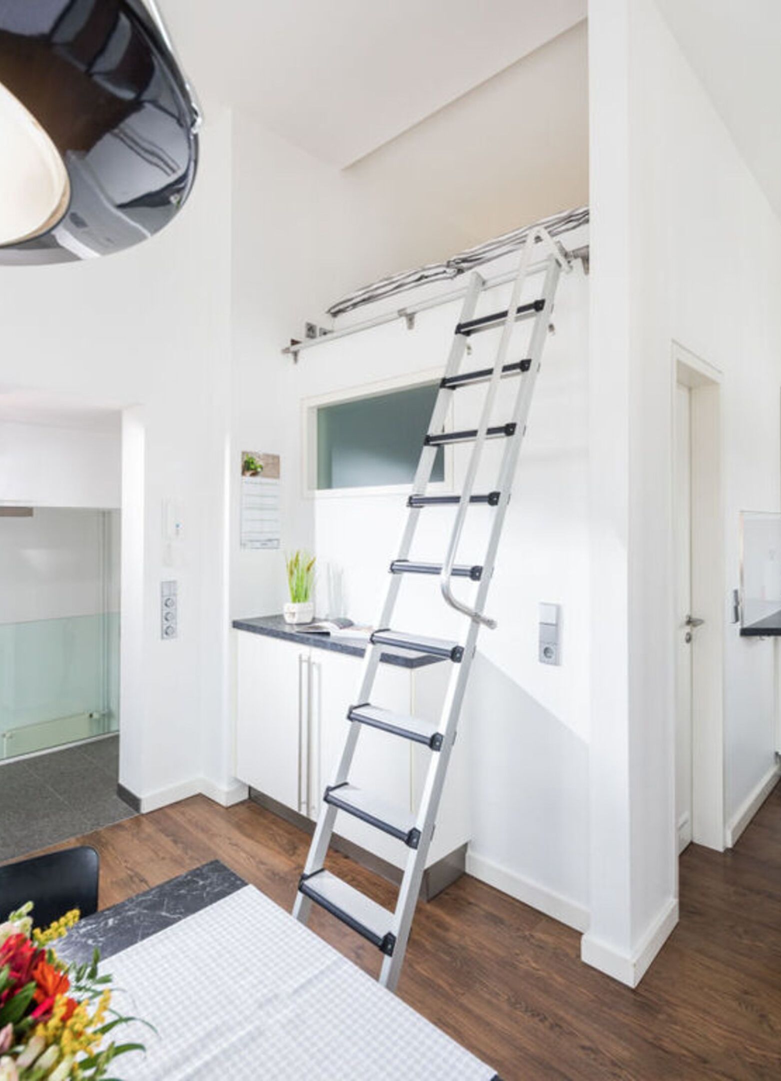 A kitchen with a white countertop, a white door, and a white wall.