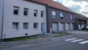 A row of two-story residential buildings with multiple windows and garage doors. - Cottage alsace bossue (Weyer)