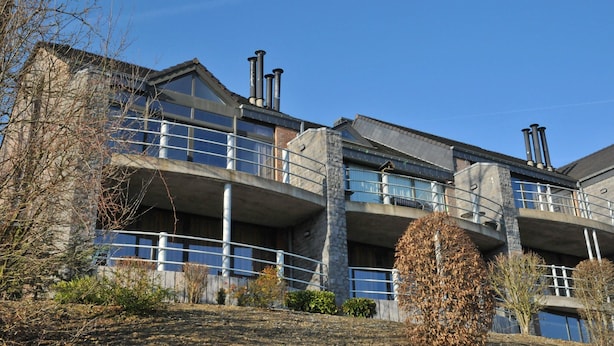 A multi-story building with balconies, large windows, and a stone facade. - House in Belgium With Pool Near Les Jardins du Golf (Durbuy)