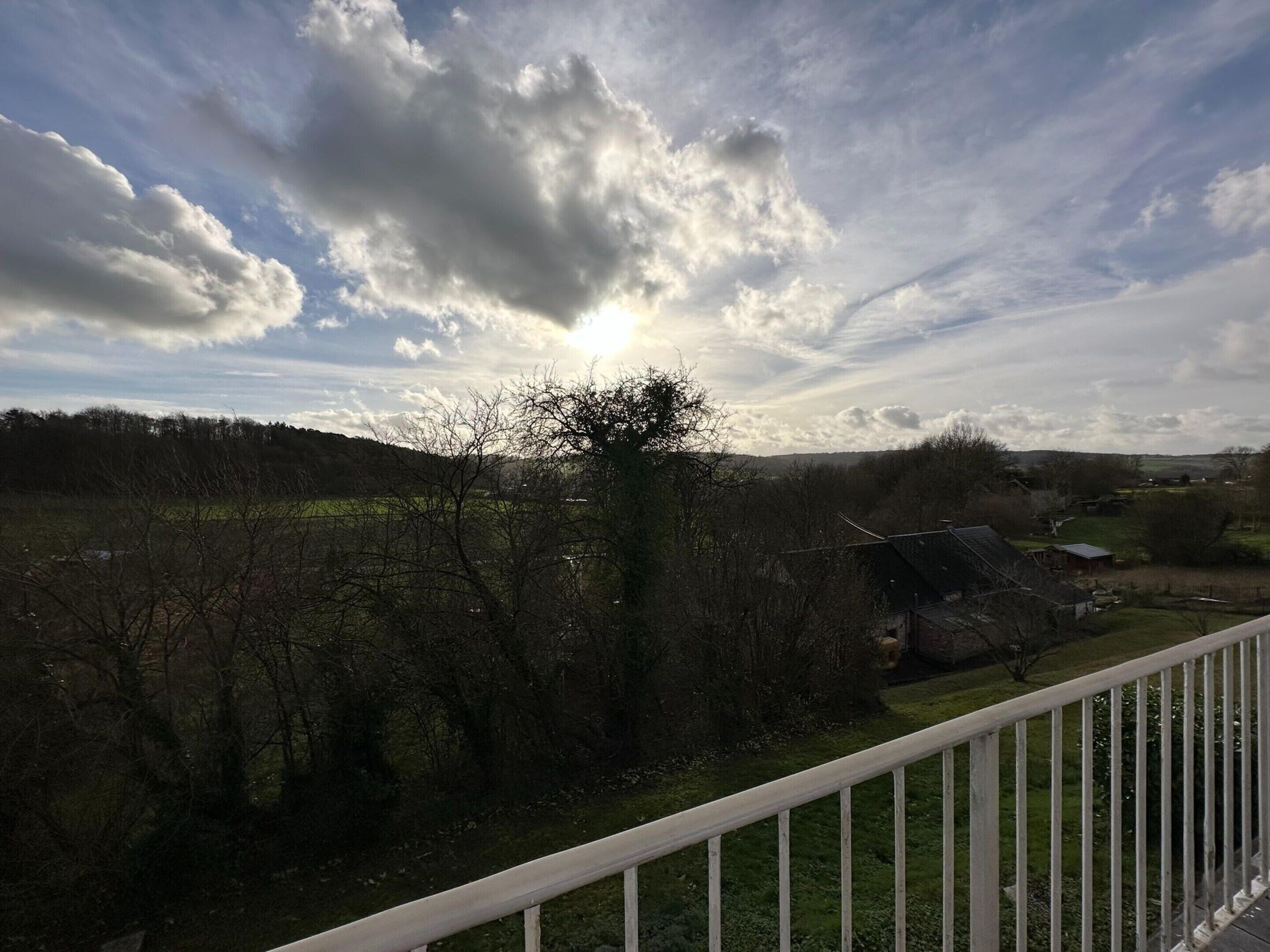 Un paysage rural avec une maison et une clôture.