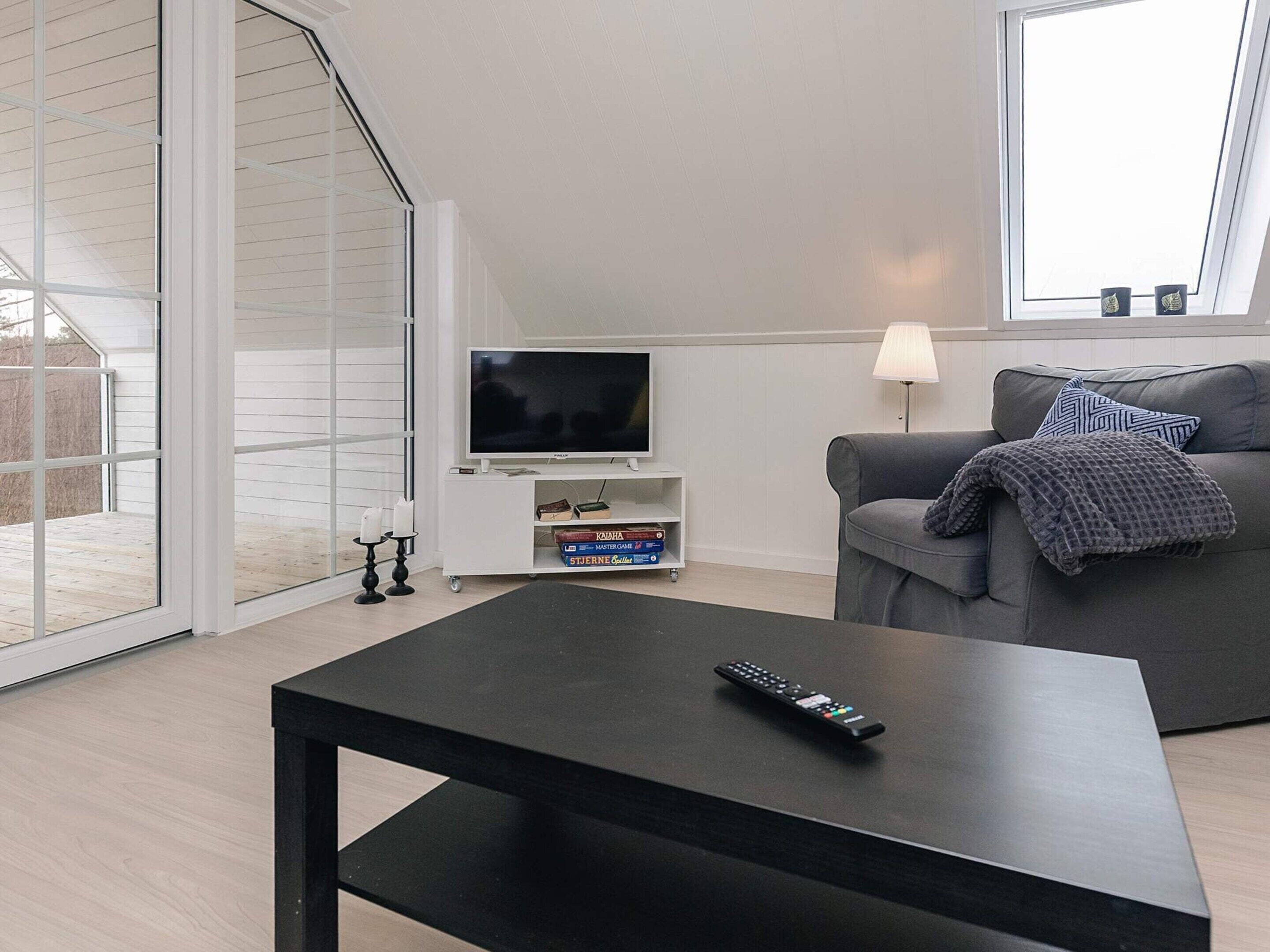 A modern living room with a television, sofa, and coffee table.