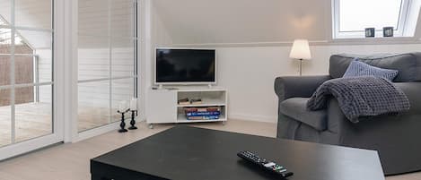 A modern living room with a television, sofa, and coffee table.