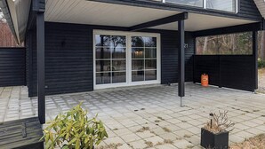A modern black house with a covered patio, large windows, and a visible number '21'.