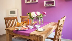 A dining table with a purple tablecloth, wooden chairs, and a variety of food items. - The Moselle Gate to Koblenz (Lehmen)