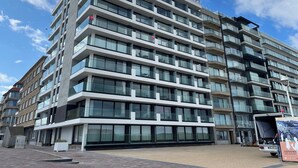 A multi-story hotel with a modern design, featuring large windows and balconies. - Apartment in Nieuwpoort Near the Beach (Nieuwpoort)