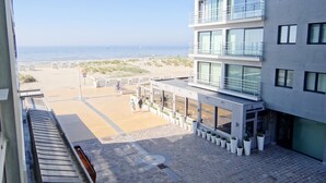 Um edifício moderno com varanda voltada para uma praia.