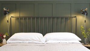 A bed with white linens, a green headboard, and two bedside lamps. - Belvilla by OYO Comfortable Apartment With Pool (Garda)