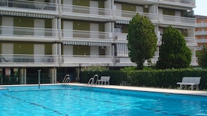 Een hotel met meerdere verdiepingen, balkons en een zwembad.