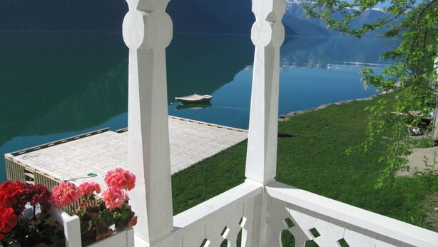Un balcone con vista su un lago e montagne.