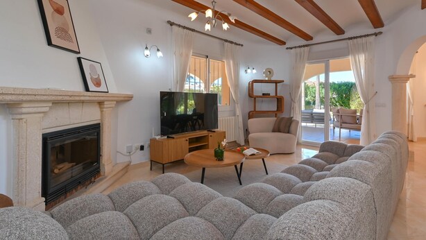 A living room with a fireplace, TV, and a sofa. - Esperanza - Javea, Costa Blanca (Javea)