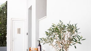 A wooden table with four chairs, a bottle of wine, and a glass on it. - Calliope's Rhodes City Comfort (Rhodes)