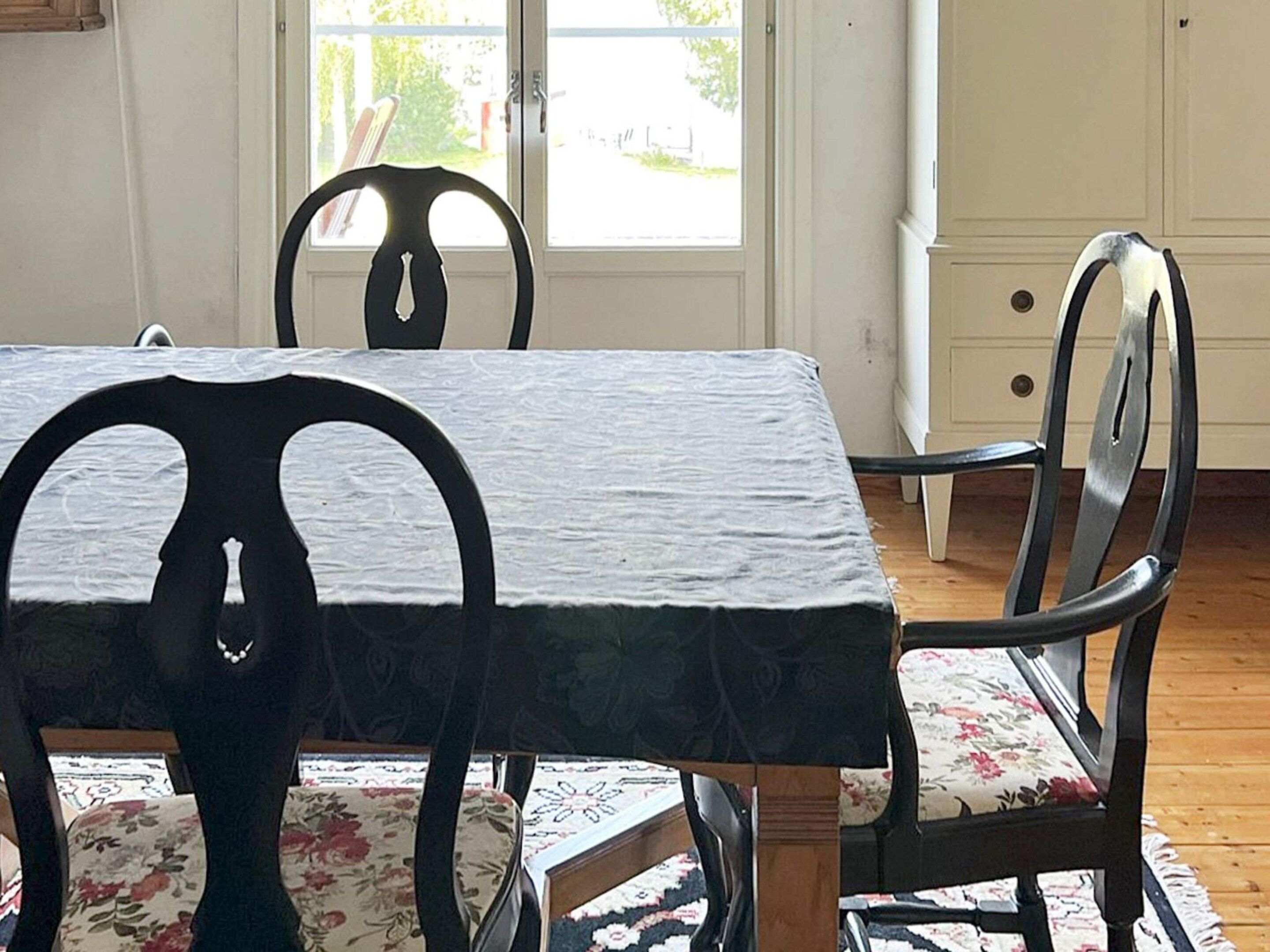 Een eettafel met stoelen, een raam met uitzicht en een deur.