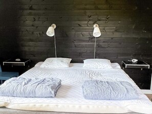 A bed with two pillows, a bedside table, and a lamp on each side. - 4 Star Holiday Home in Tronodal (Trönödal)