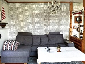 A modern living room with a sectional sofa, a chandelier, and a patterned wallpaper. - 4 Star Holiday Home in Tronodal (Trönödal)