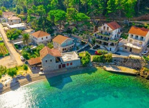 A coastal residential area with houses, a clear blue sea, and a rocky shoreline. - Apartments Vela Stiniva - Two Bedroom Apartment With Terrace and Sea View (Jelsa)