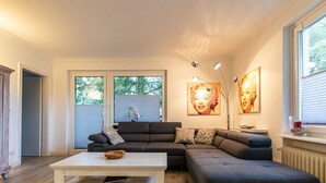 A modern living room with a sectional sofa, a coffee table, and artwork on the walls. - Hexengluck Hahnenklee (Goslar)