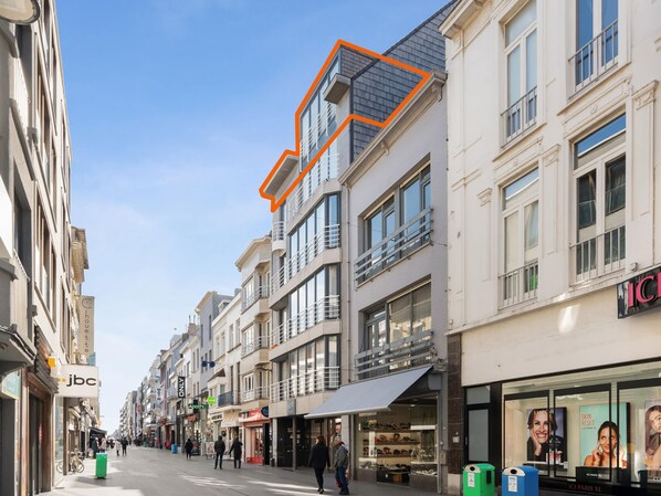 Une vue de rue avec des immeubles, des boutiques et des piétons.