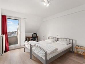 Une chambre avec deux lits, un bureau et une chaise.