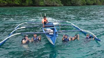 A group of people in a blue boat with a central platform, surrounded by water.