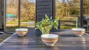 A wooden deck with three striped bowls and a potted plant. - 5 Star Holiday Home in Hovborg (Hovborg)