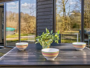 A wooden deck with three striped bowls and a potted plant. - 5 Star Holiday Home in Hovborg (Hovborg)