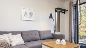 A modern living room with a grey sectional sofa, a wooden coffee table, and a framed artwork on the wall. - 5 Star Holiday Home in Hovborg (Hovborg)