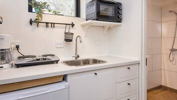A modern kitchen with a built-in microwave, a coffee maker, and a sink.