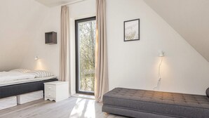 A bedroom with a bed, bedside table, and a window with curtains. - 5 Star Holiday Home in Hovborg (Hovborg)
