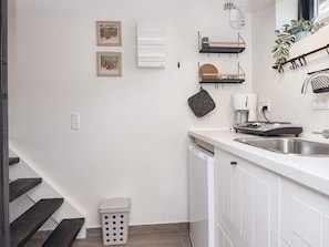 A modern kitchen with white cabinetry, a stainless steel sink, and a coffee maker. - 5 Star Holiday Home in Hovborg (Hovborg)