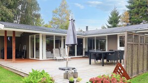 A covered patio with outdoor furniture, a table, and chairs. - 4 Star Holiday Home in Idestrup (Idestrup)