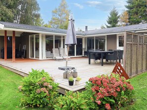 A covered patio with outdoor furniture, a table, and chairs. - 4 Star Holiday Home in Idestrup (Idestrup)