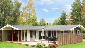 A house with a covered patio, outdoor seating, and a fenced garden area. - 4 Star Holiday Home in Idestrup (Idestrup)