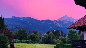 A mountain landscape with a building in the foreground.