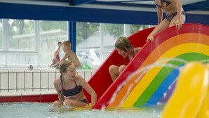 Uno scivolo acquatico con un motivo a arcobaleno in una piscina.