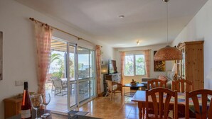 A dining area with a table, chairs, and a view through a glass door to an outdoor patio. - Holiday Home in Playa Blanca (Yaiza)