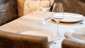 A dining table with a white plate, a fork, a knife, and two wine glasses. - Comfortable Apartment in Salzburger Land (Neukirchen am Grossvenediger)