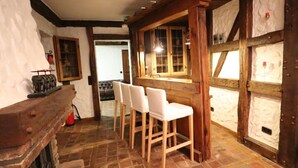 Un intérieur rustique avec des tabourets de bar en bois, un comptoir en bois et une cheminée.