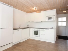Una cocina moderna con gabinetes blancos, horno integrado y microondas.
