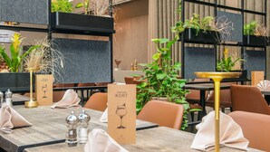 A restaurant setting with wooden tables, chairs, and potted plants. - 6 Person Holiday Park Home in Blavand (Blavand)