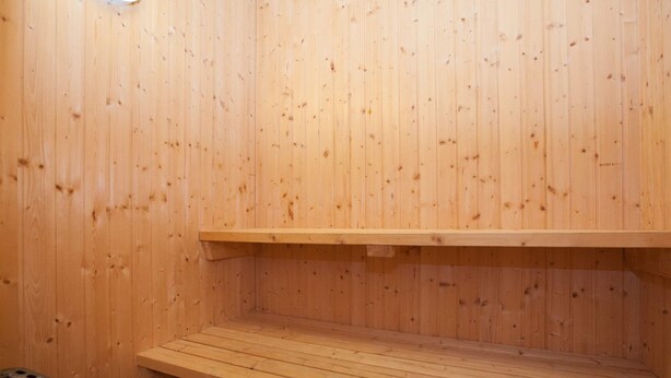 A wooden sauna with a bench and a shelf. - 6 Person Holiday Park Home in Blavand (Blavand)