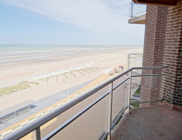 A balcony with a view of a beach and a construction site.