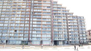 A multi-story residential building with balconies, large windows, and a central courtyard. - Apartment in Nieuwpoort With Terrace (Nieuwpoort)