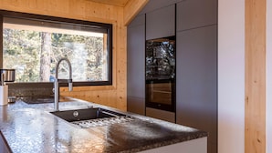 A modern kitchen with a granite countertop, stainless steel sink, and built-in appliances.